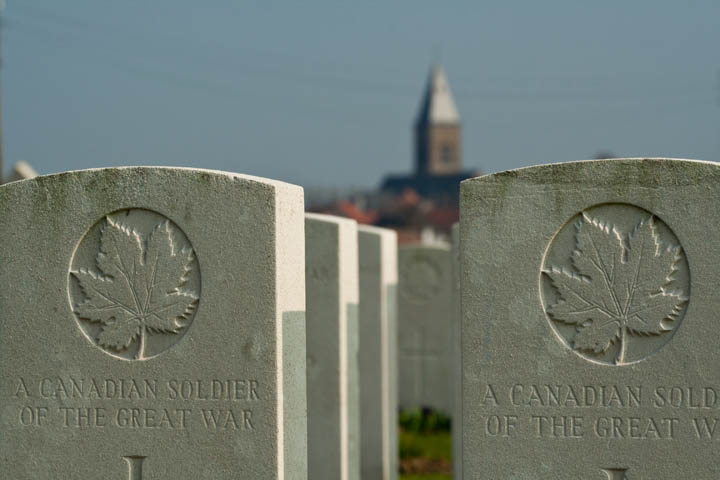 Passchendaele Cemetery, near Ypres, Belgium. The village of Passchendaele in background.